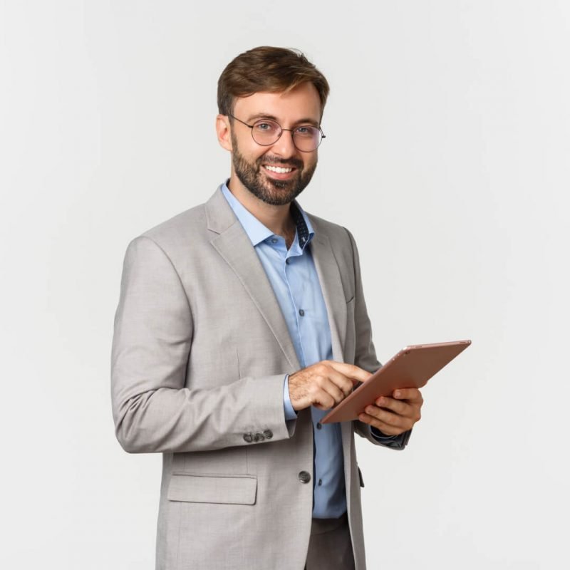 Smiling professional in a suit and glasses using a tablet