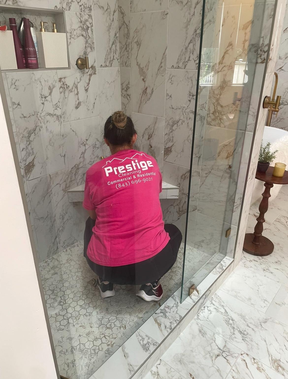 Prestige Cleaning technician detailing a marble shower
